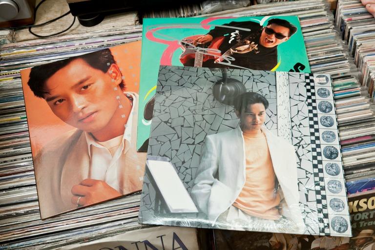 [圖片：龍軒商行專家正在專注地鑑定黑膠唱片]