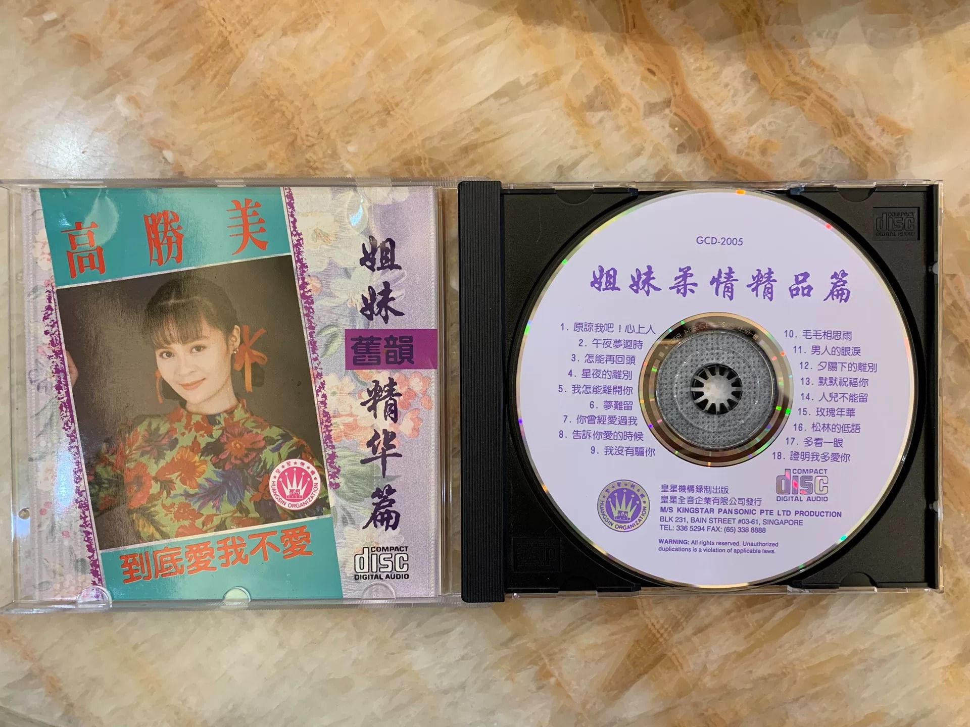 同一張專輯的舊 CD 封面、封底曲目表與光碟內圈並排核對
