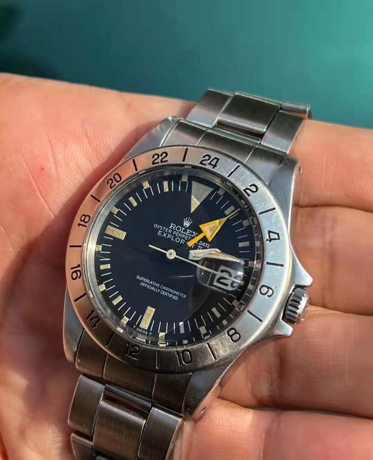 黑色錶面 Explorer II 的固定 24 小時外圈及橙色箭頭指針近照