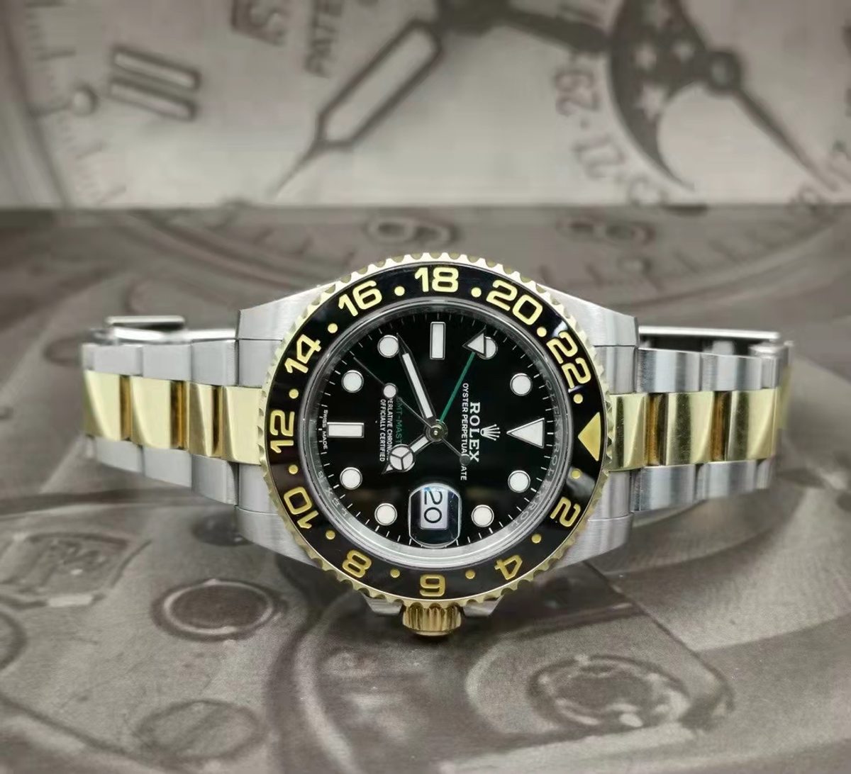銀金雙色金屬外觀的 GMT-Master II，可見黑色 24 小時外圈、綠色箭頭指針與蠔式錶帶