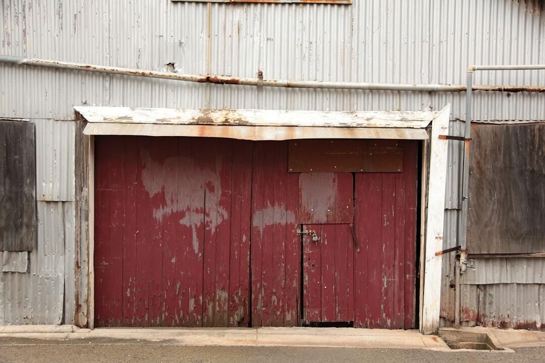 old red painted wood garage doors in bad condition