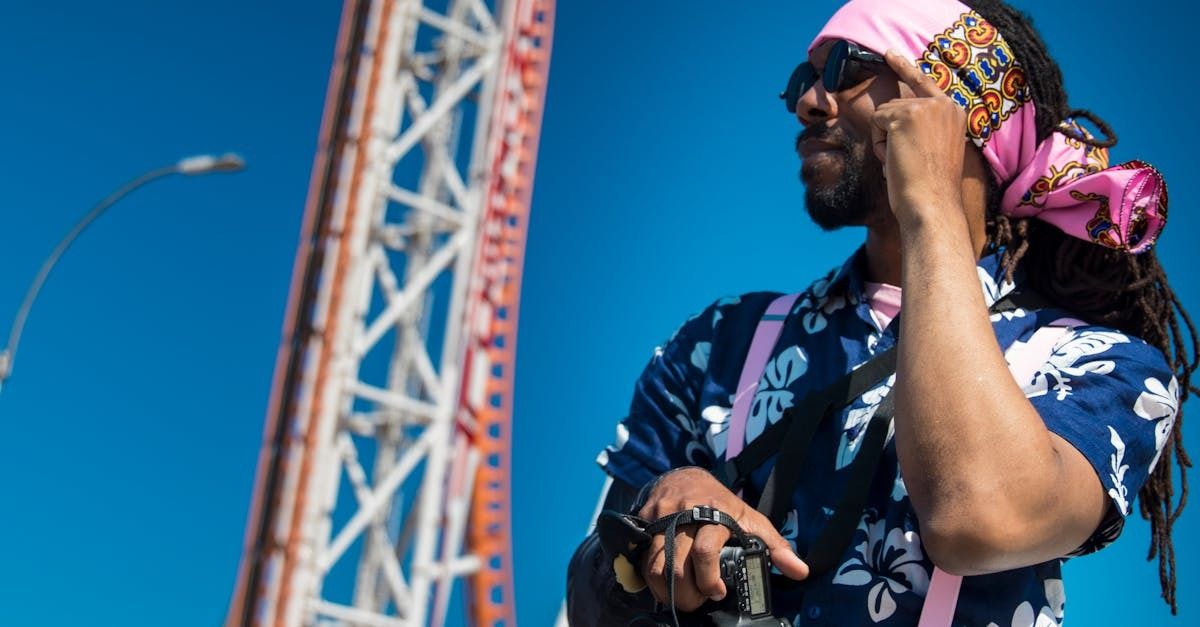 young man wearing a bandana on his head while adjusting his sunglasses