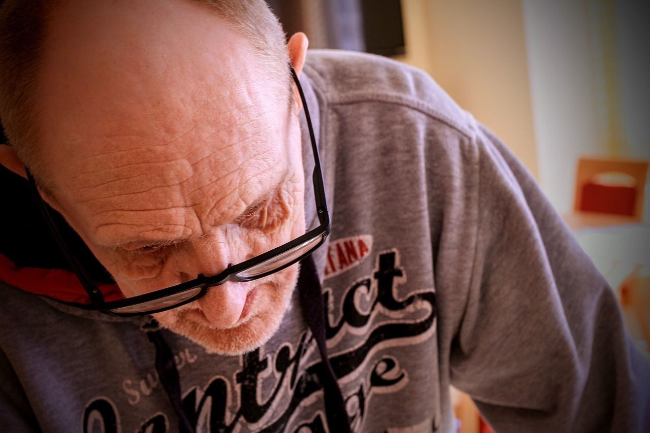 Image of a man wearing glasses looking at his work