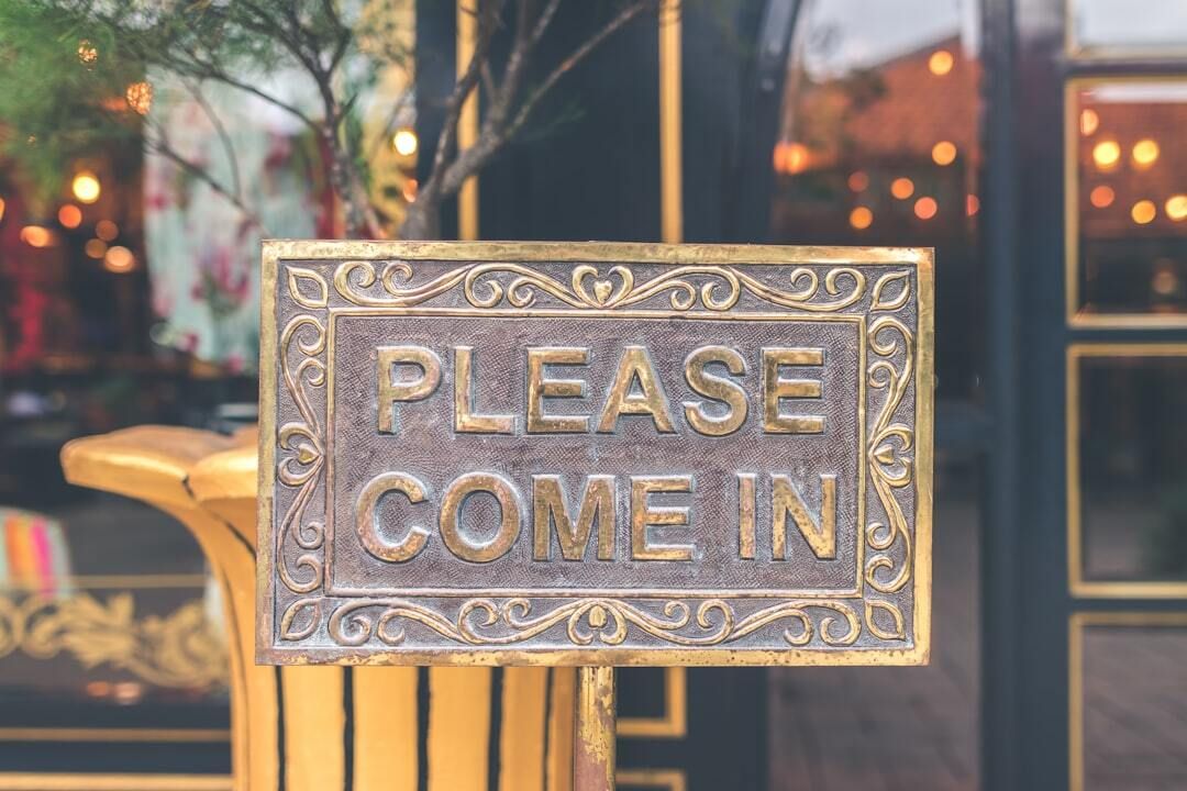 brass sign that says Please Come In
