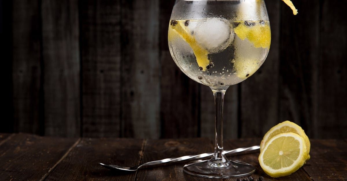 Gin cocktail with lemon and ice on a wooden bar
