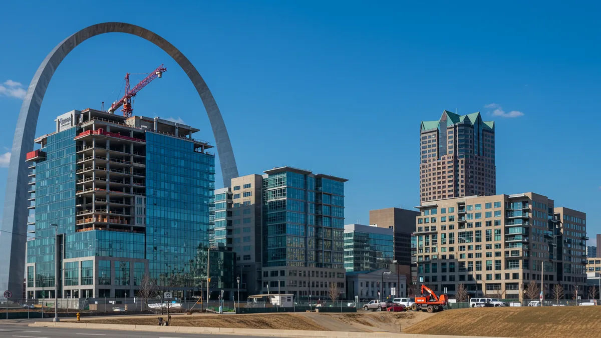 modern downtown St. Louis office and residential buildings with construction development under a blue sky Editorial photograph, natural lighting, realistic, high quality. No text,