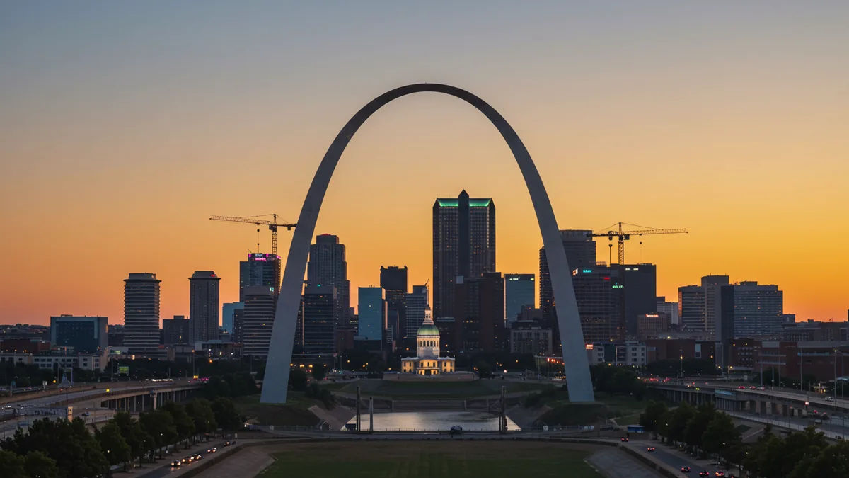 the downtown St. Louis skyline with the Gateway Arch at golden hour, cranes and new construction suggesting growth Editorial photograph, natural lighting, realistic, high quality.