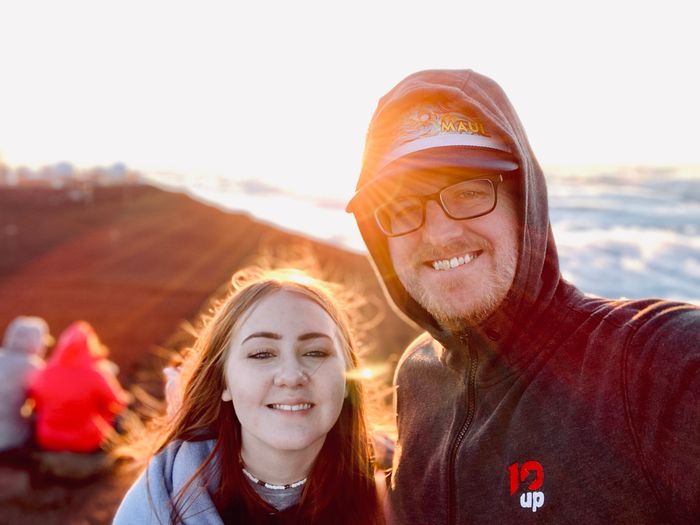 my daughter and I posing for a photo at sunset on Mount Haleakala in Maui, Hawaii