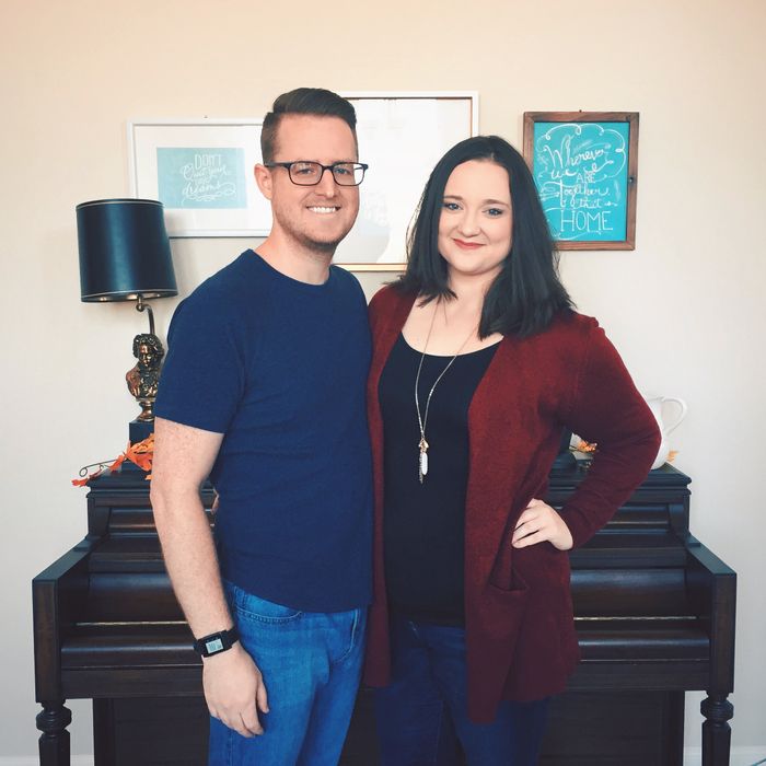 me and my wife posing in front of her mom's family heirloom piano