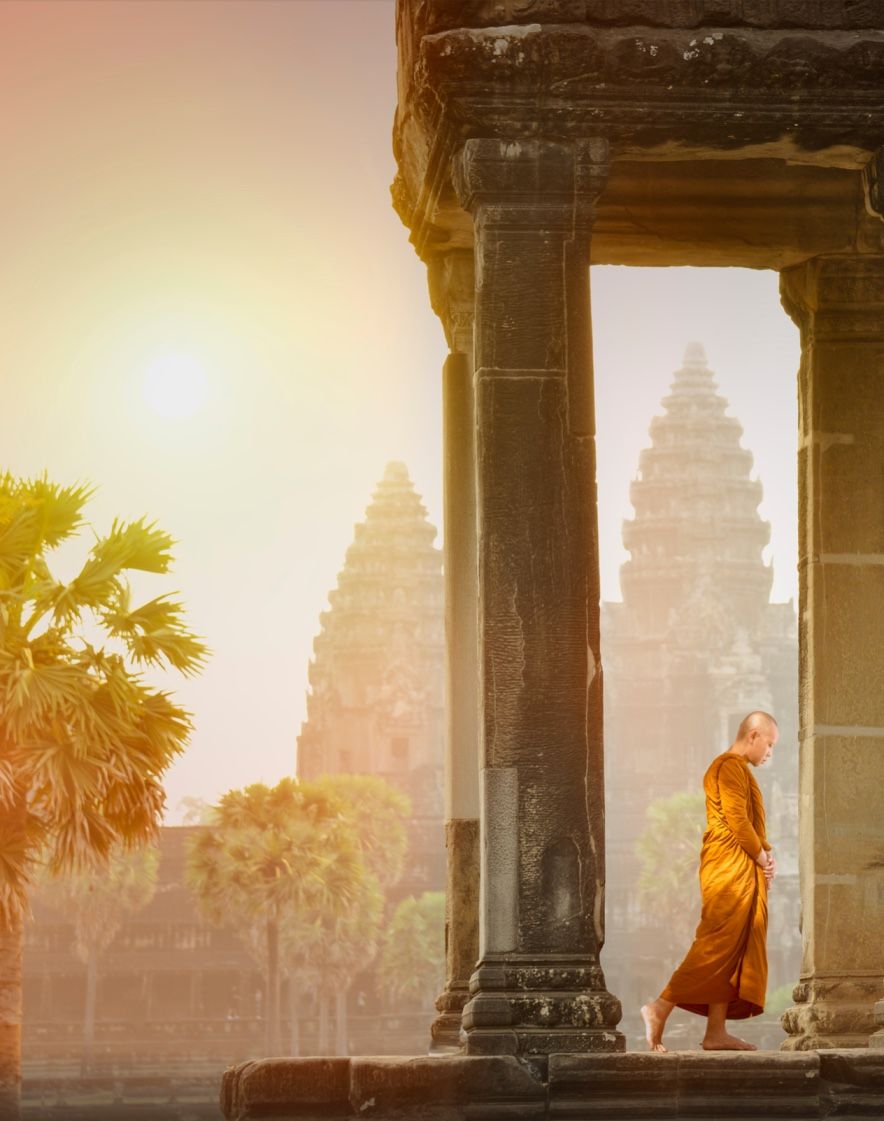 A monk walking through the temples in angkor complex - book cambodia tours