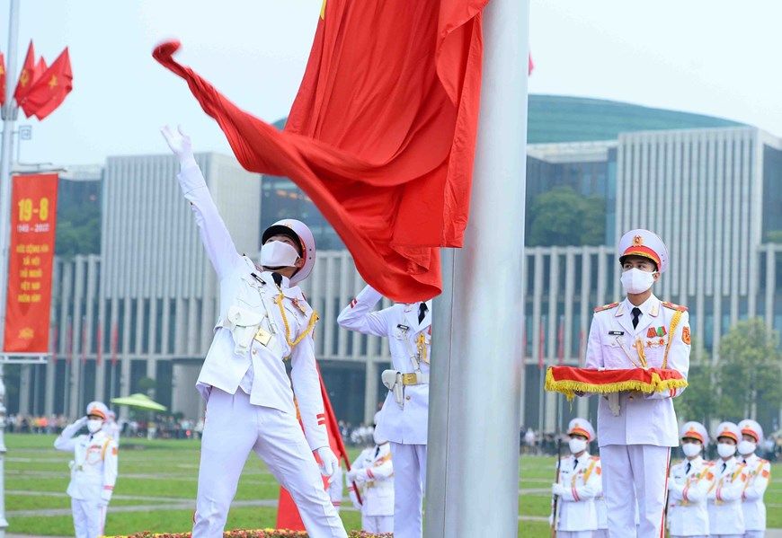 Vietnam flag raising ceremony with vietnamese national anthem playing in the background is holding daily at 6 am in Hanoi's ba dinh square and infant of the mausoleum of Ho Chi Minh