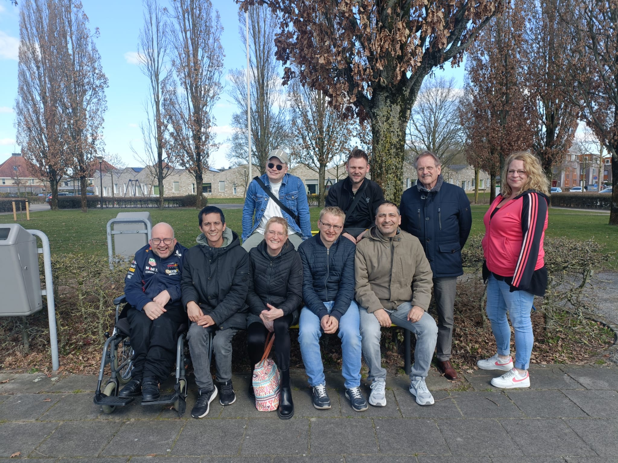 G groep deelnemers van De Koninklijke Loop in Apeldoorn poseert voor een foto op de Veluwe, inclusief rolstoelgebruiker