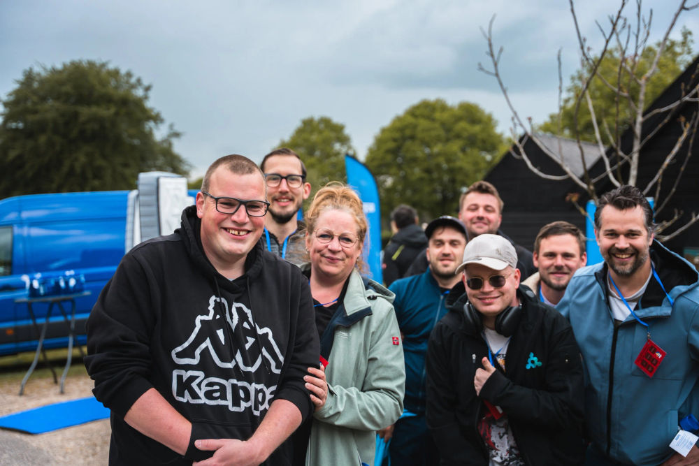 Een lachende groep deelnemers staat bij elkaar tijdens De Koninklijke Loop.