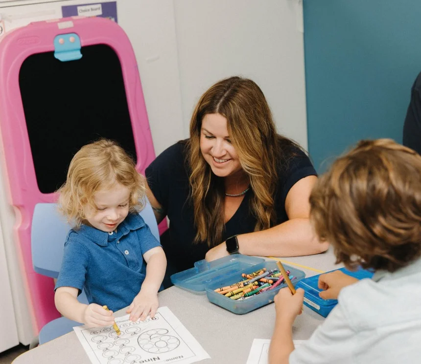 Children coloring with ACES team member