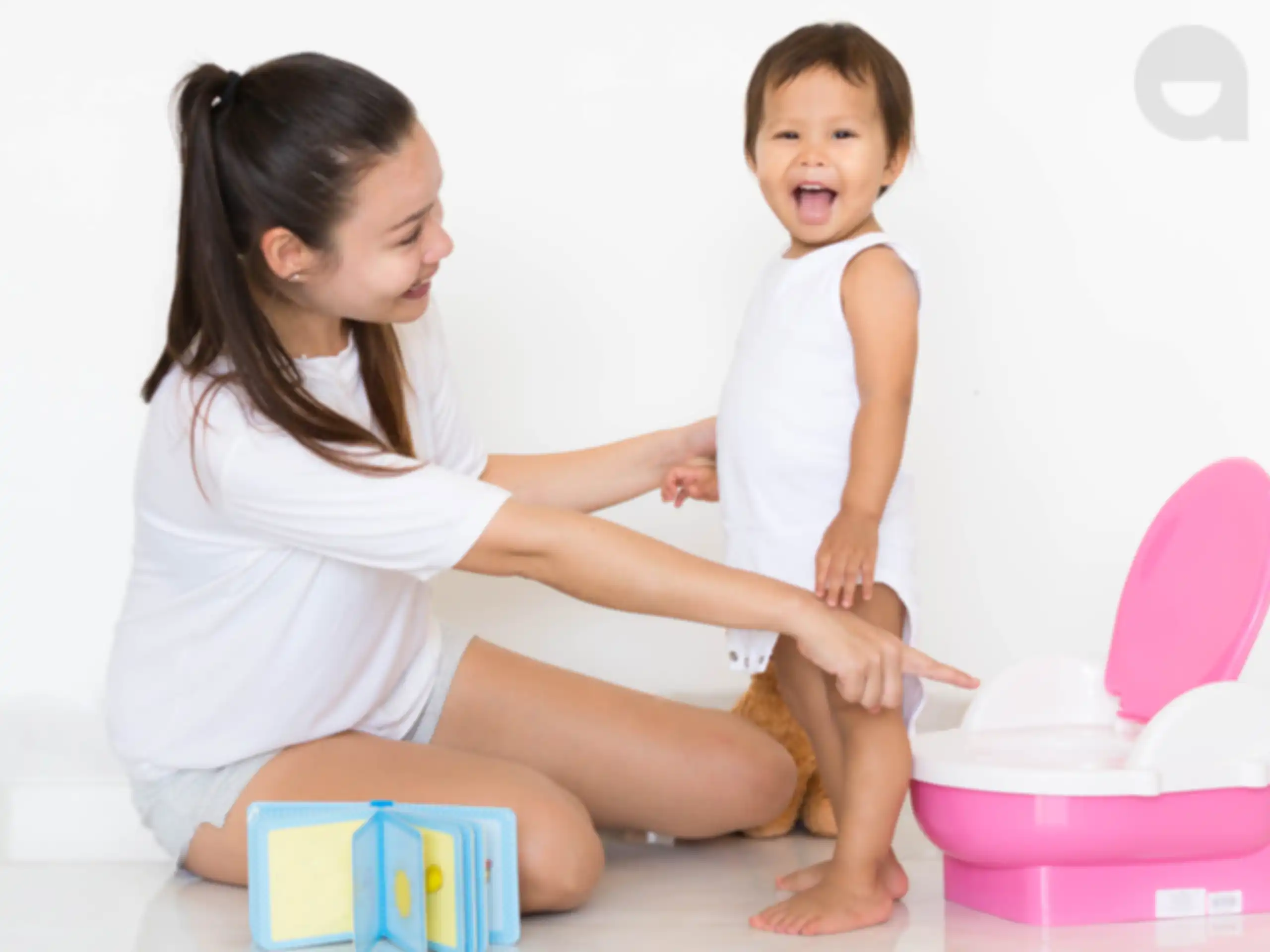 Mother pointing at potty, child happy