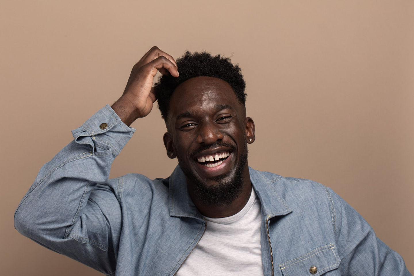 Studio portrait of a young man laughing.