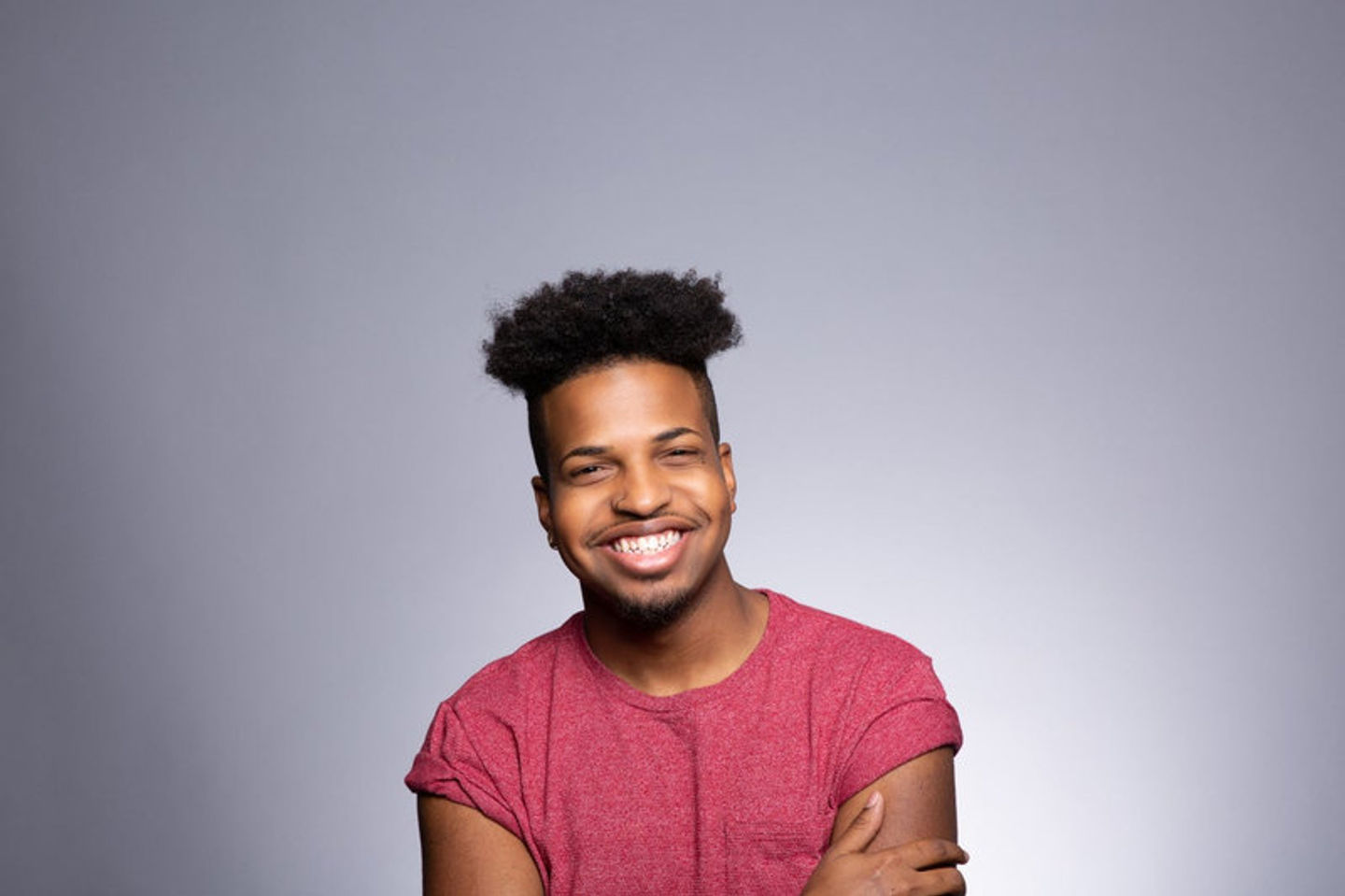 Studio portrait of a young man in a red shirt.