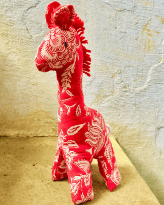 Sustainable handmade giraffe toy with embroidered details, crafted from cotton fabric.