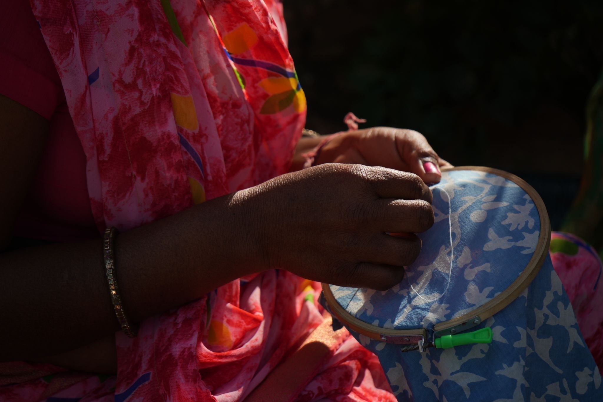 Close-up of an artisan’s hands stitching fabric at the Mysa workshop