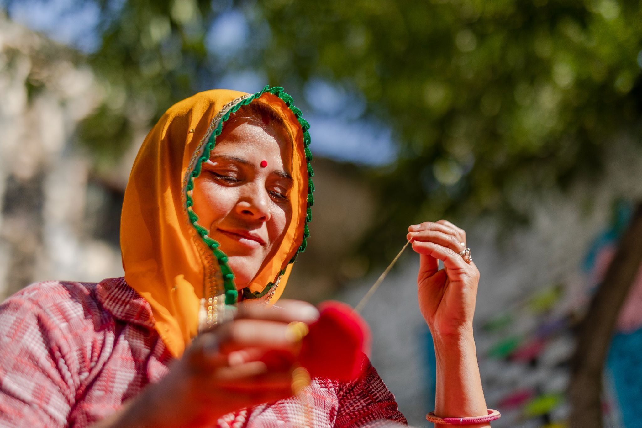Woman artisan hand-stitching a fabric product at Mysa 