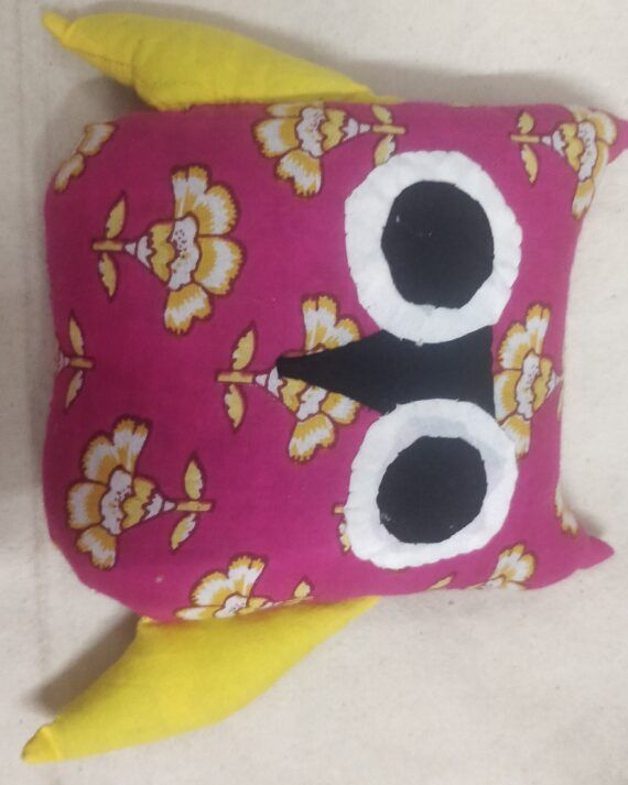Magenta floral cotton owl toy with large black-and-white fabric eyes, a black beak and yellow wings.