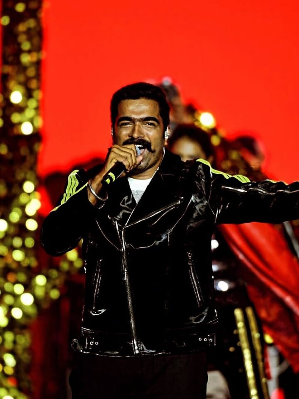 Ravi Basrur performing onstage with a microphone.