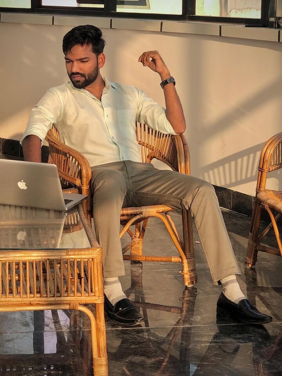 Shoaib Mustaque seated beside an open laptop.