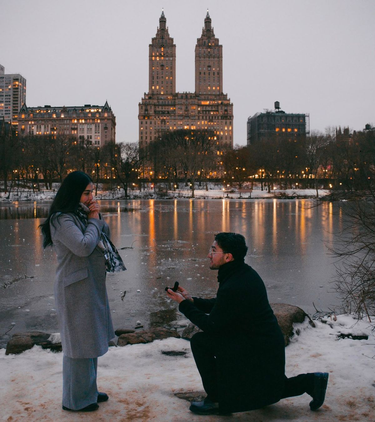 Salvador, de rodillas sobre la nieve, le ofrece el anillo a Katia junto al lago helado de Central Park.