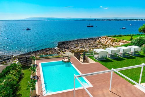 Villa Angelina Villa de luxe à Plemmirio, Sicile, Italie, avec piscine privée pour 8 personnes. La villa est située dans un quartier résidentiel en bord de mer, à 25 mètres d'un accès direct à la mer et aux rochers en contrebas de la plage....