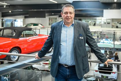 Der diplomierte Verkaufsleiter Sandro Studerus steht in dem Showroom von einem Autohaus.}