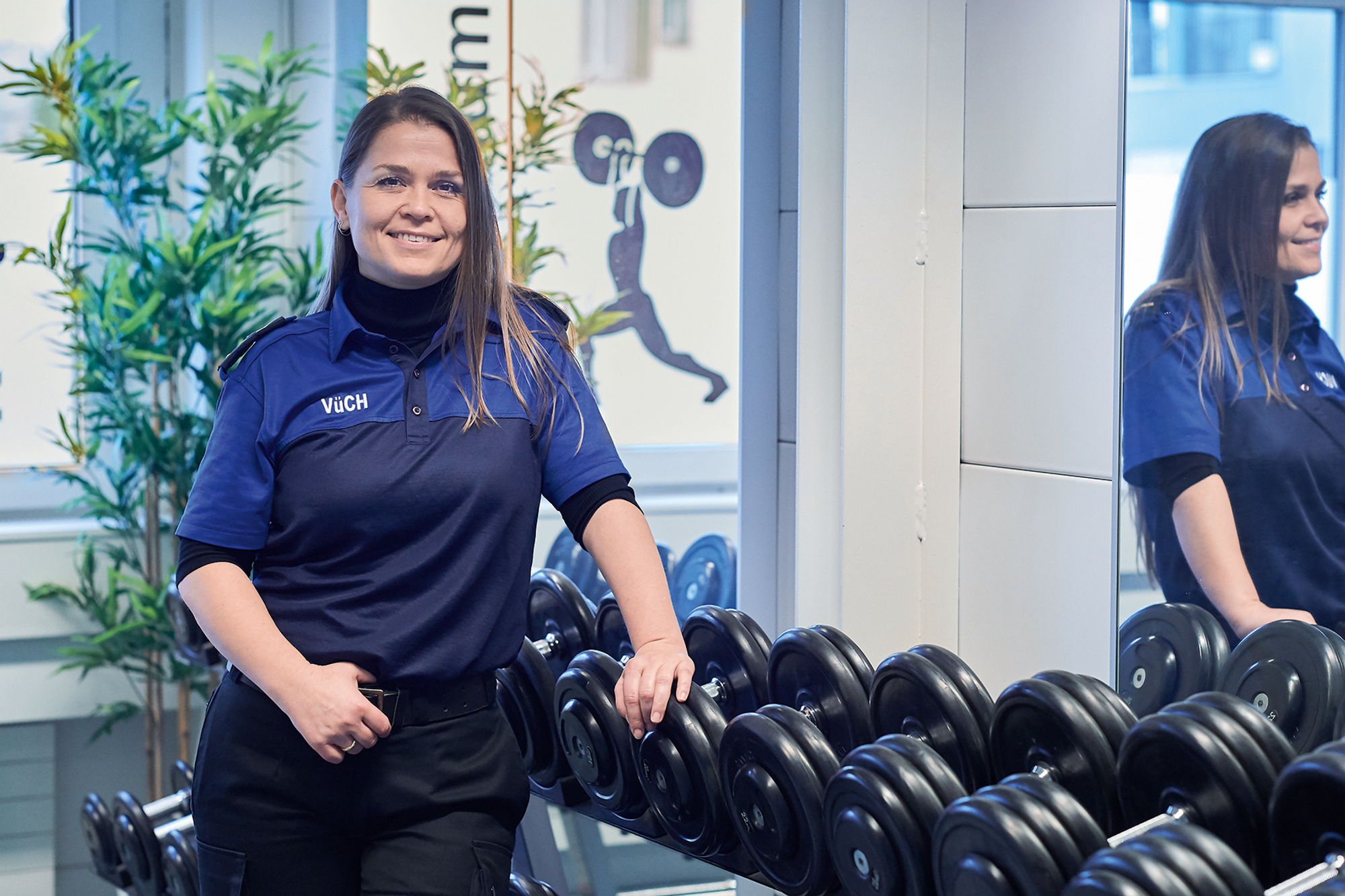 Isamete Asani im Fitnesscenter vor einer Hantelbank