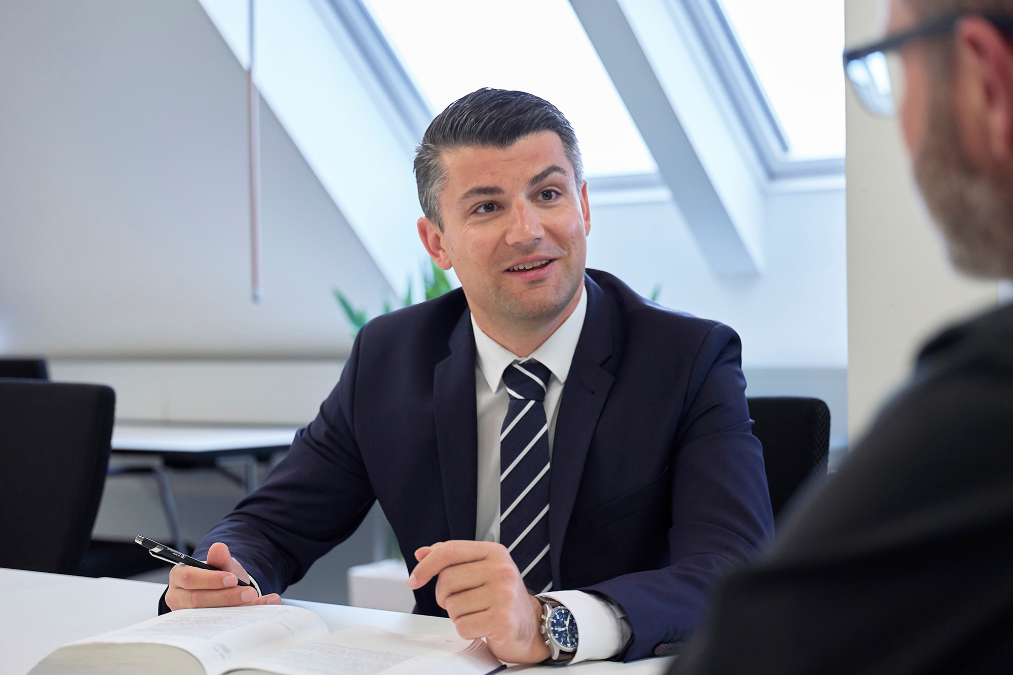 Bogdan Todic ist in einem Meeting und diskutiert mit einem Stift in der Hand