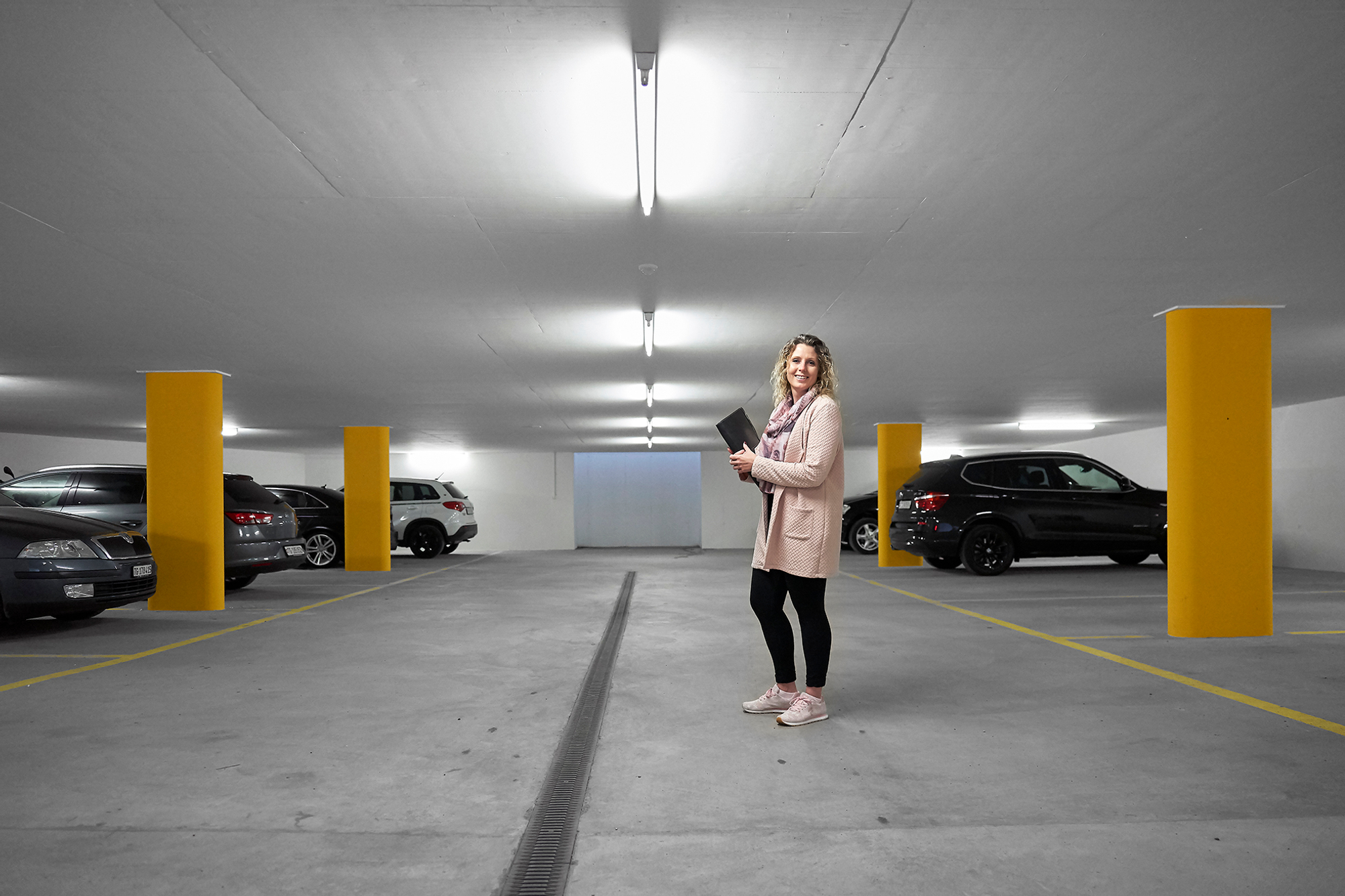 Claudia Strässle in einer Tiefgarage mit Laptop im Arm