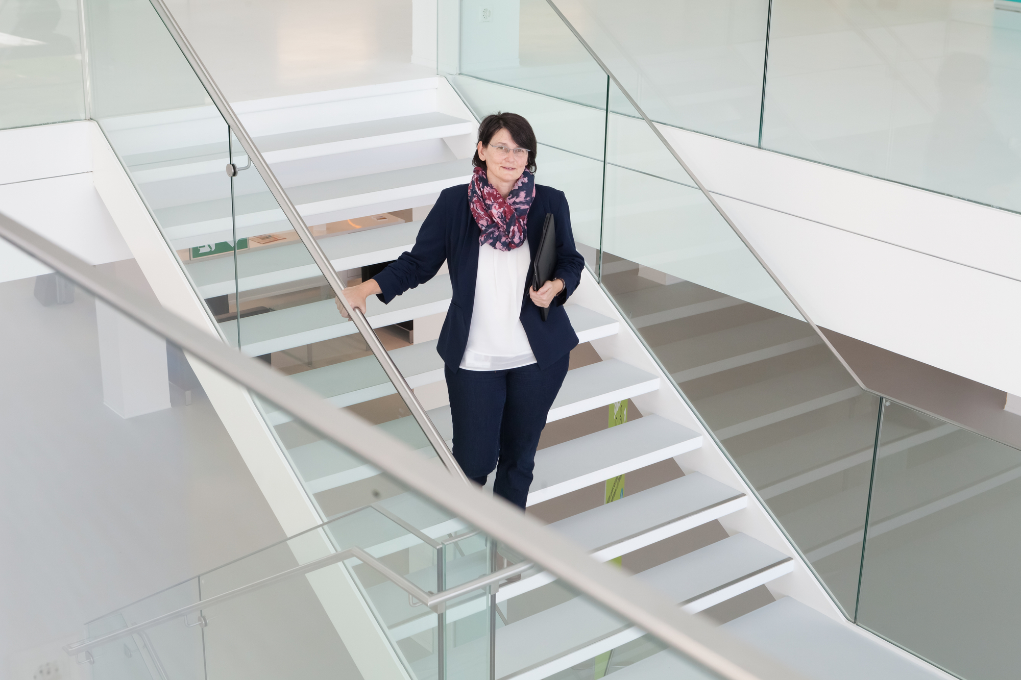 Daniela Theus steht auf einer Treppe und schaut in die Kamera