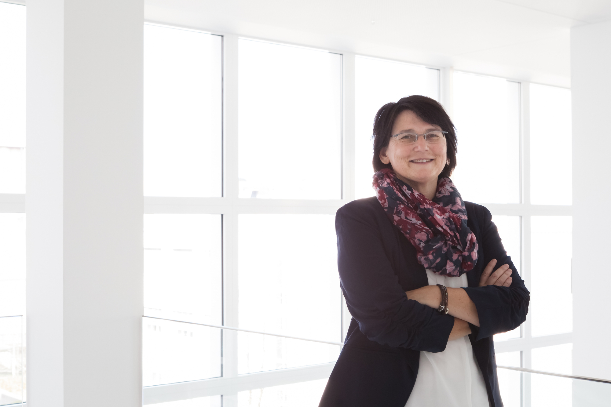 Daniela Theus lächelt mit verschränkten Armen in die Kamera