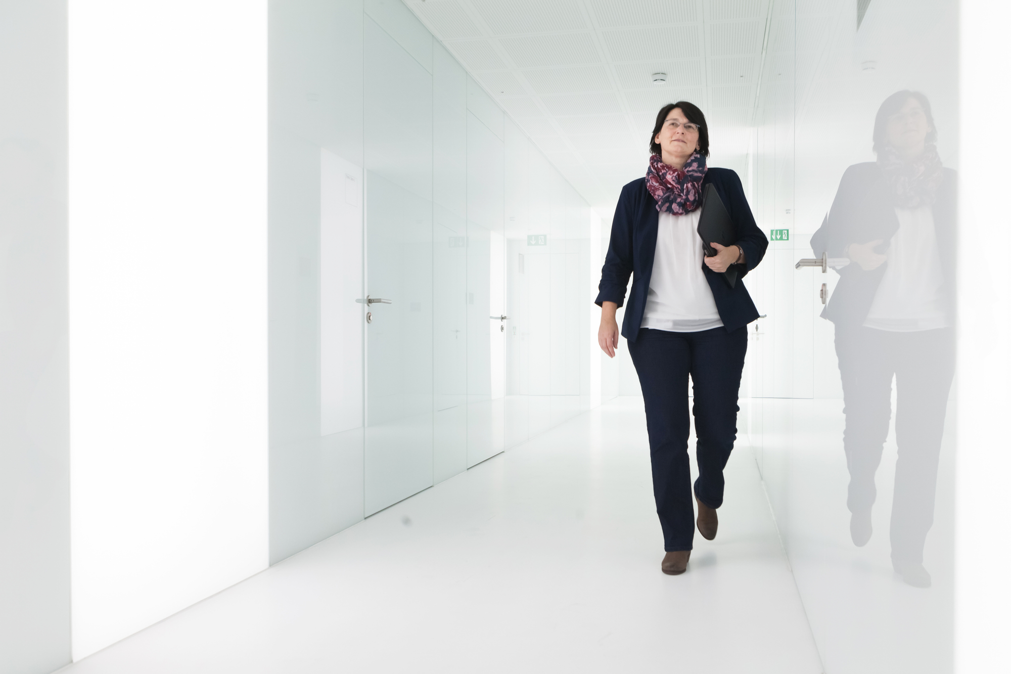 Daniela Theus läuft einen weissen Gang entlang in der Bühler AG