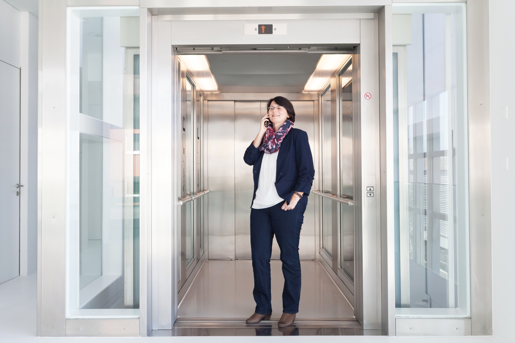 Daniela Theus steht im Lift der Bühler AG und telefoniert
