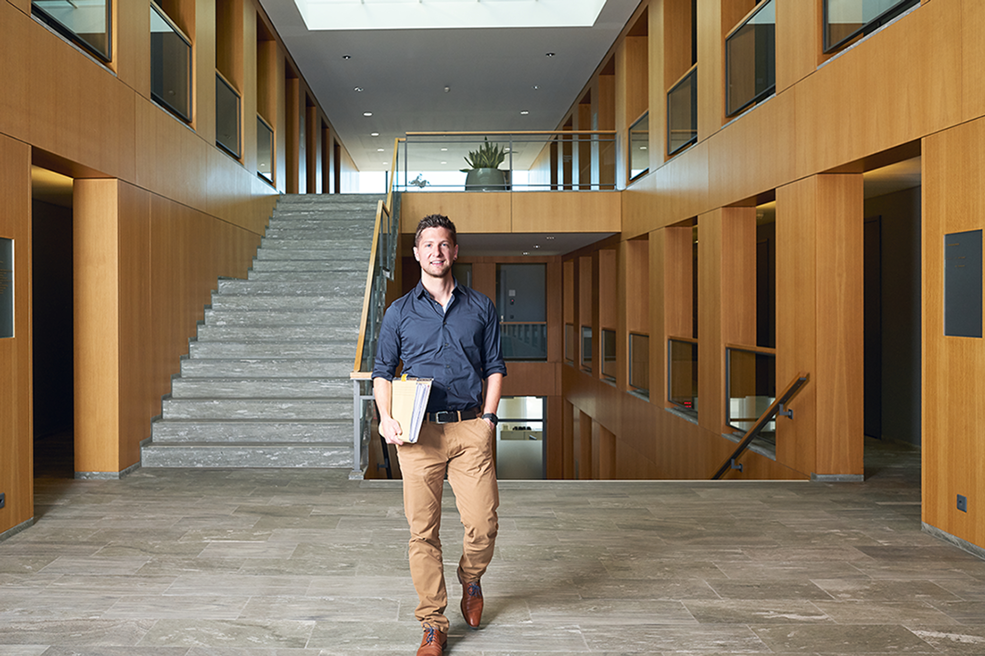 Stefan Eberhard läuft auf die Kamera zu, unter dem Arm hält er Pendenzen