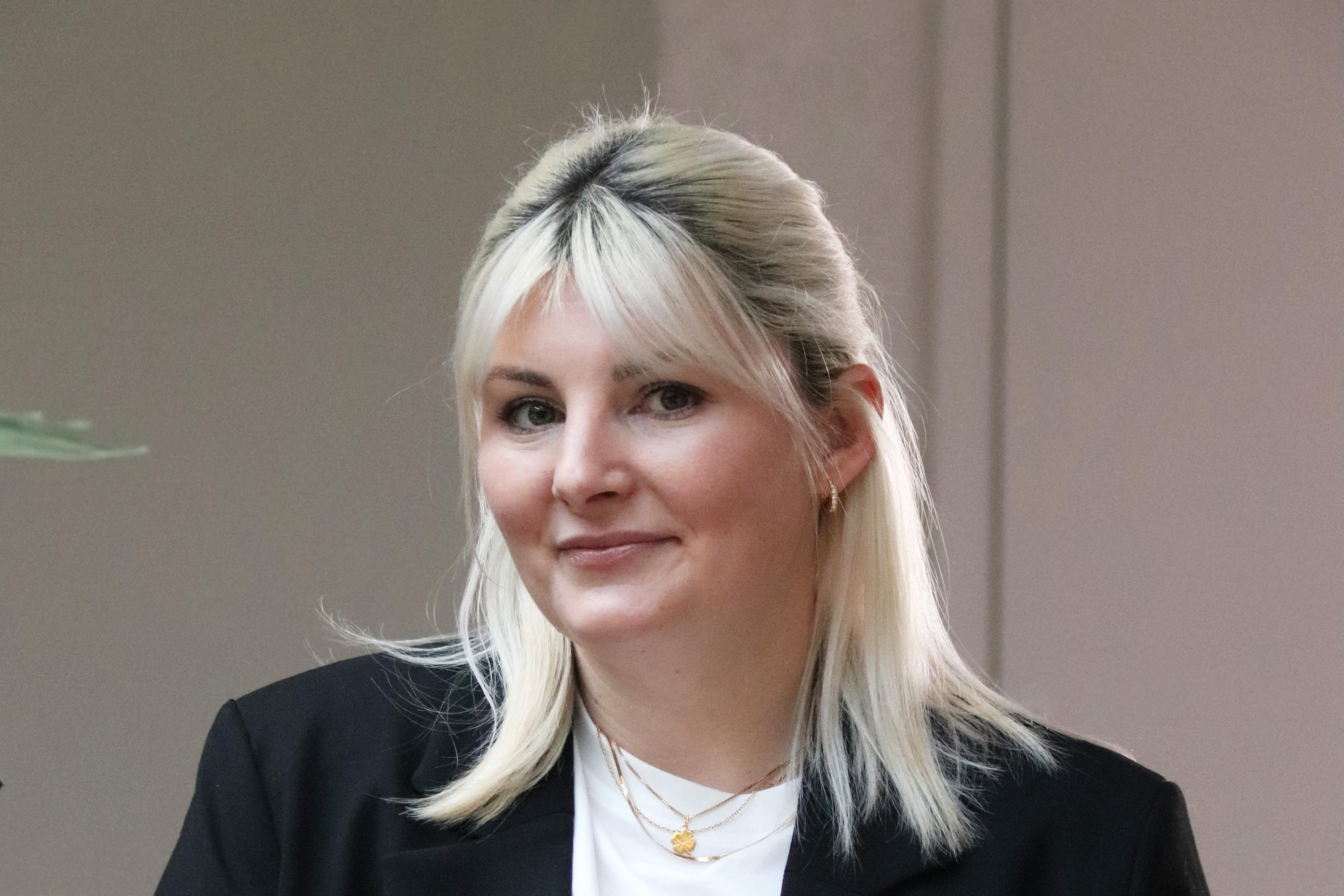 Lara Damljanovic lächelt in die Kamera und steht neben einer Pflanze Lara Damljanovic lächelt in die Kamera und steht neben einer Pflanze