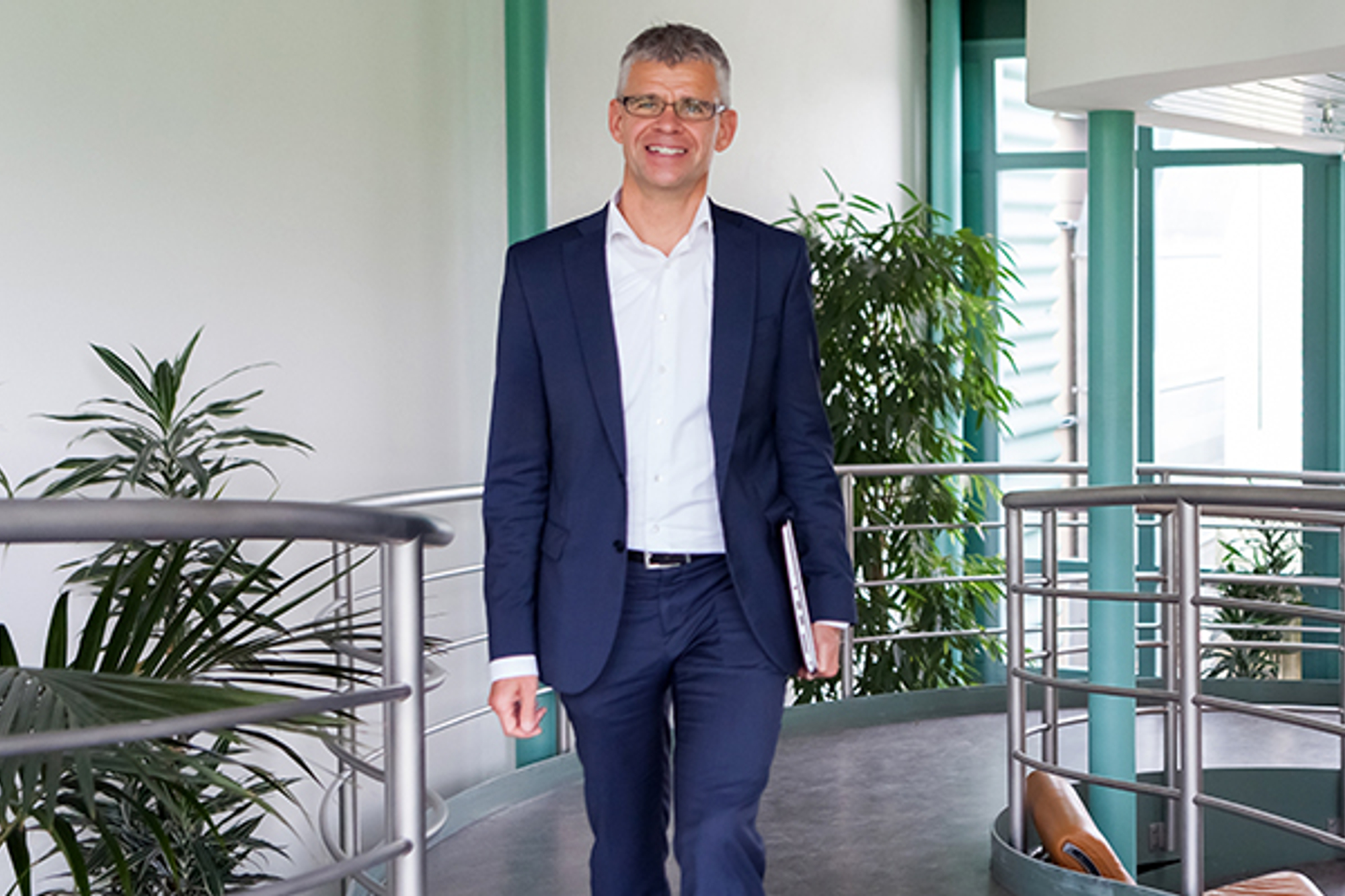 Marcel Haener läuft in einem blauen Anzug gegen die Kamera und lächelt