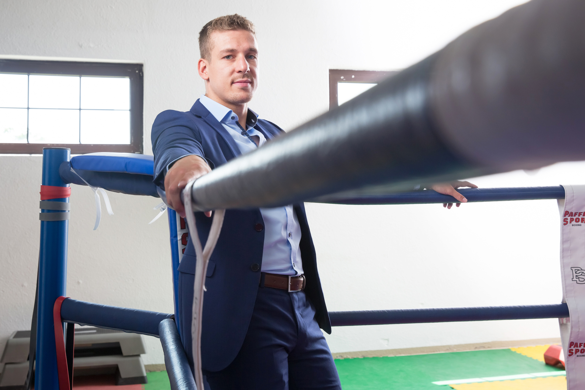 Zino Meuli steht mit Anzug in der Ecke des Boxrings