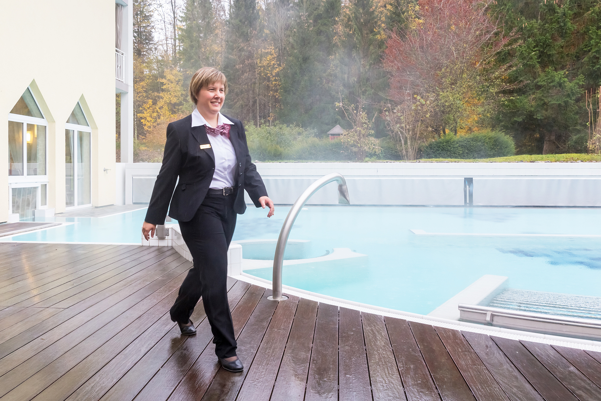 Monika Vetsch-Graf läuft in einem schwarzen Anzug der Wellnesslandschaft entlang