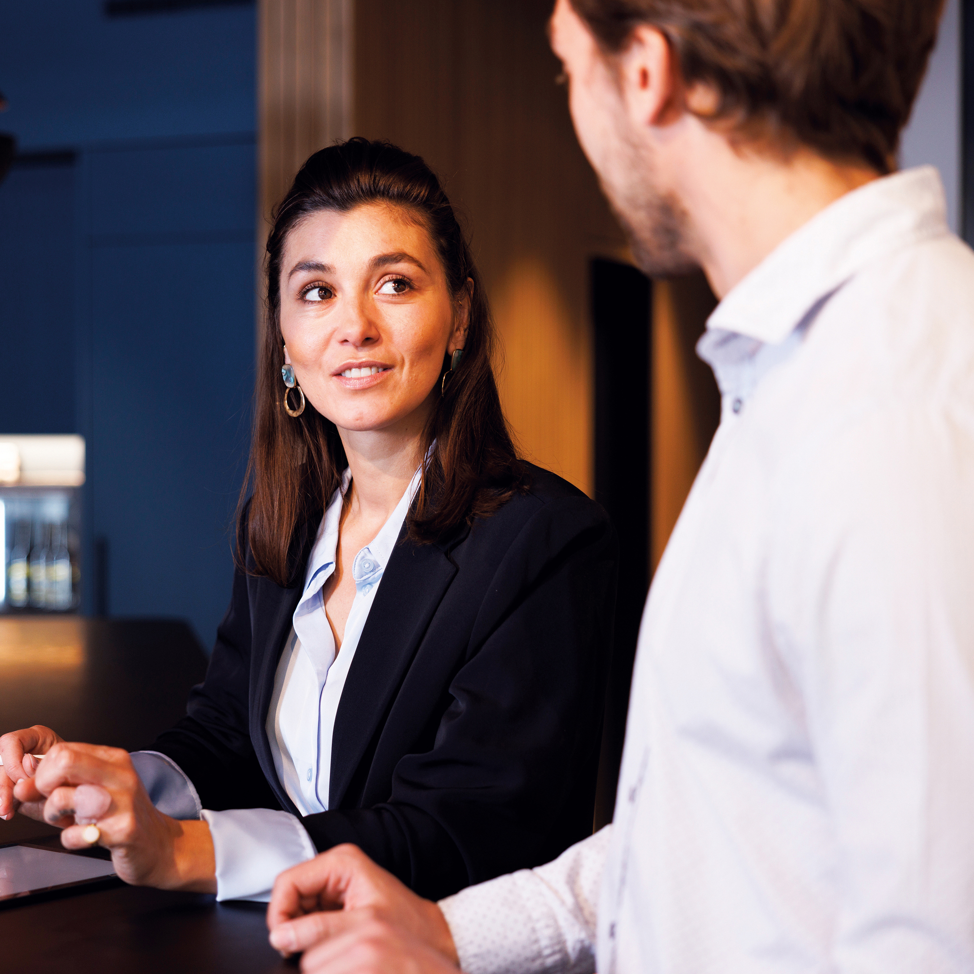 Eine Frau und ein Mann halten ein Meeting. Die Notizen werden von der Frau auf einem IPad geführt.