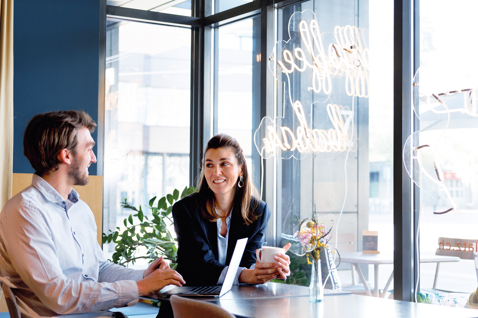 Mann und Frau sitzen in einem Business Kaffee und arbeiten Remote