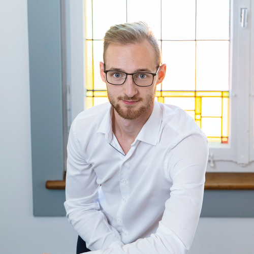 Steve Ackermann lächelt in die Kamera und trägt ein weisses Hemd