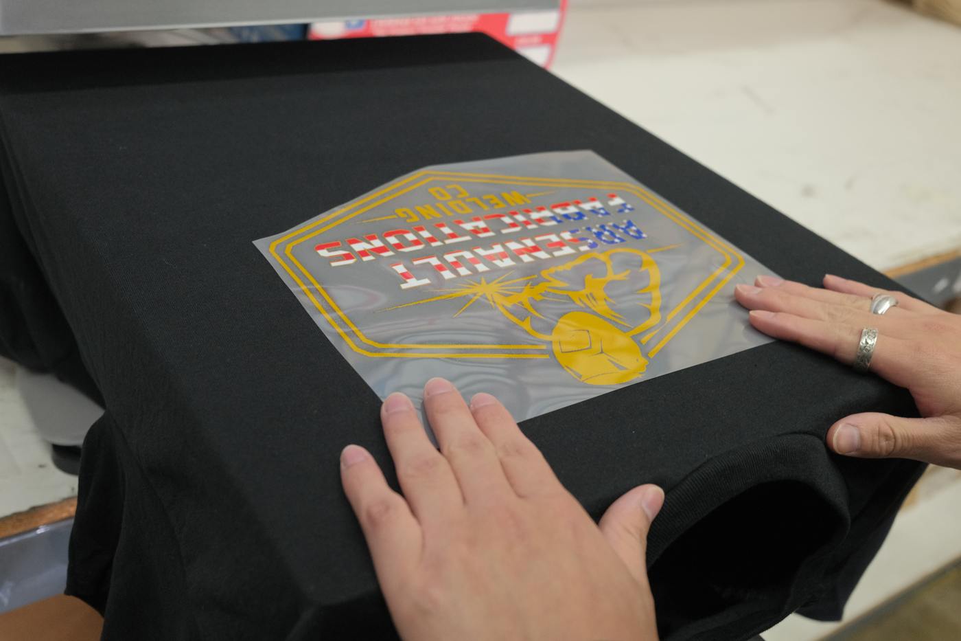 Digital print film being applied to custom Greek apparel in-house at Greek Casual Anaheim CA