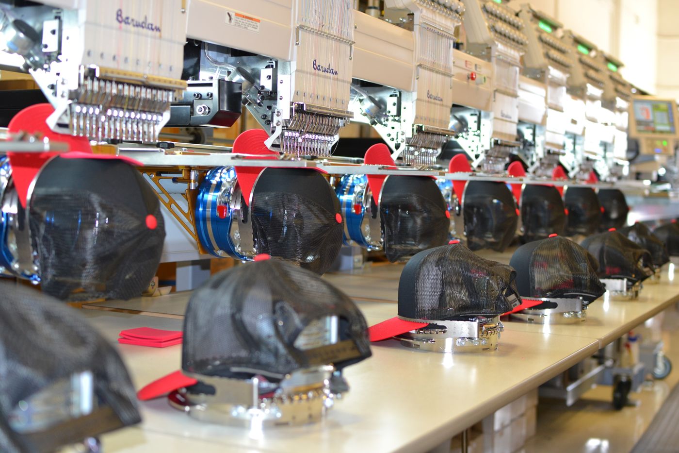 Hats loaded on embroidery machine at American Casual in Anaheim
