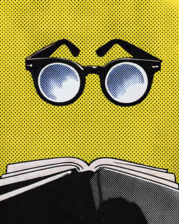 A pair of glasses resting above an open book.