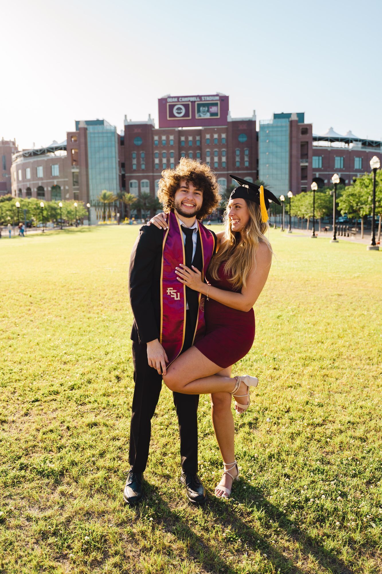 Couple graduation photo in front of the FSU stadium