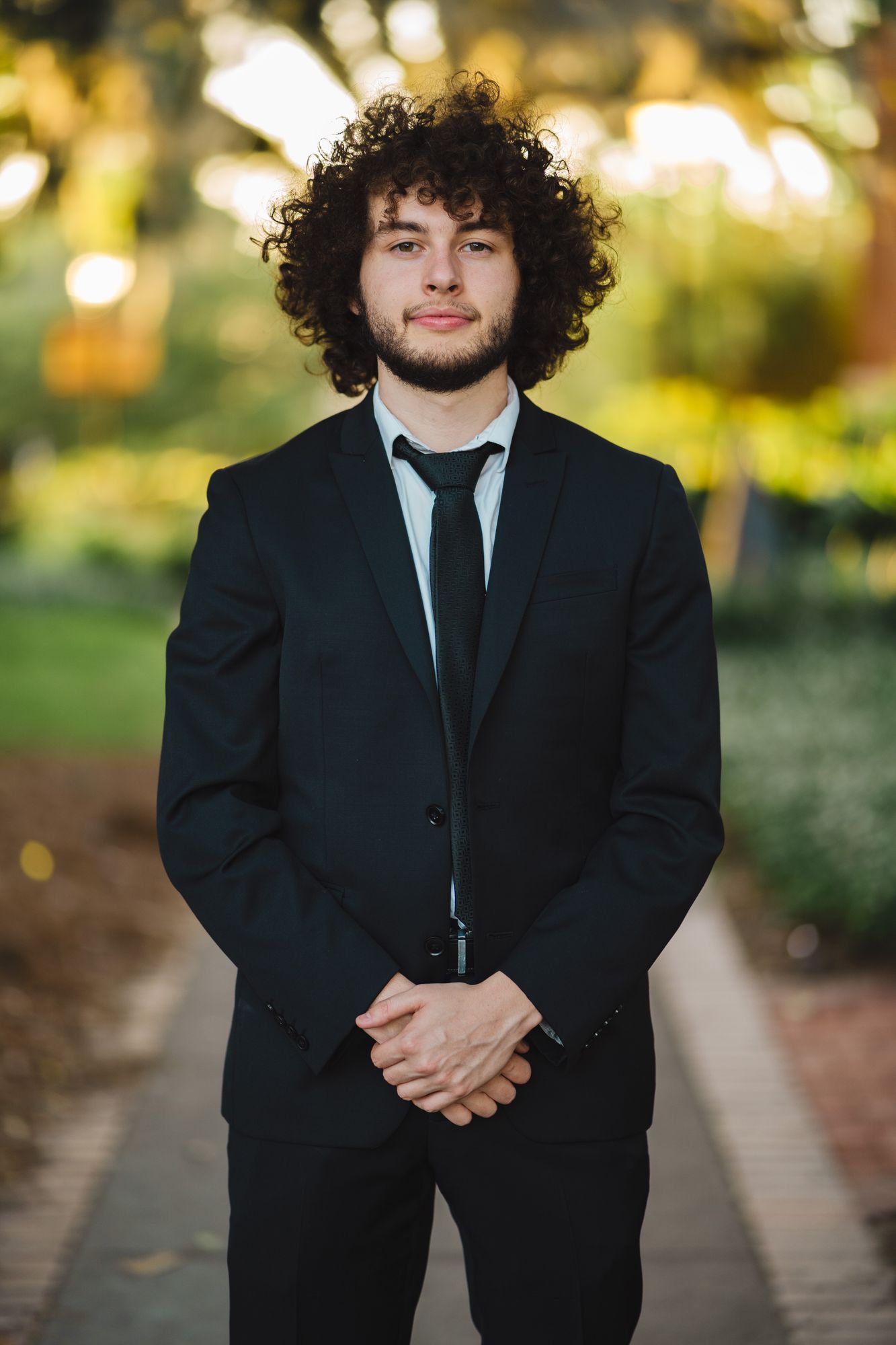 Professional headshot photo in the arch with a green background